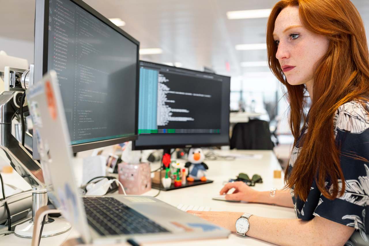 participação feminina na ciência - mulher em frente ao computador analisando dados e códigos de programação